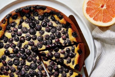 A Blueberry Breakfast Cake cut into slices on a platter, ready to be served.